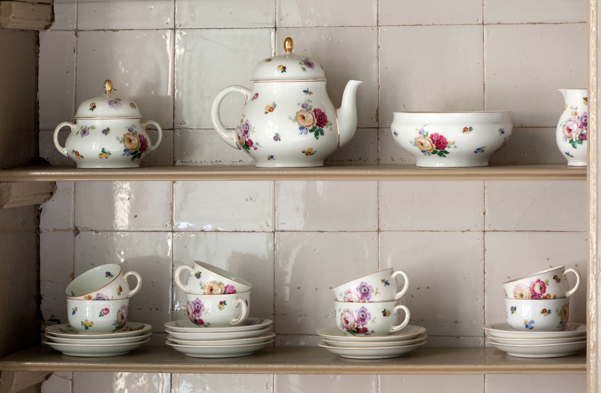 © Trudelies de Graaf Historisch servies op een plank tegen de betegelde keukenwand — foto © Trudelies de Graaf