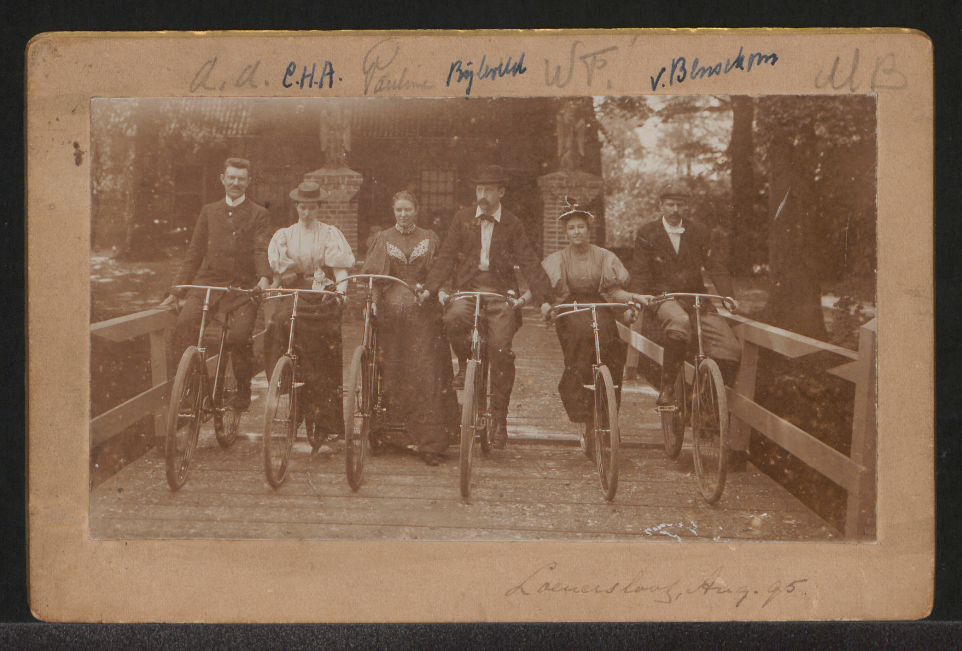 Historische groepsfoto met zes mensen en fietsen op de kasteelbrug